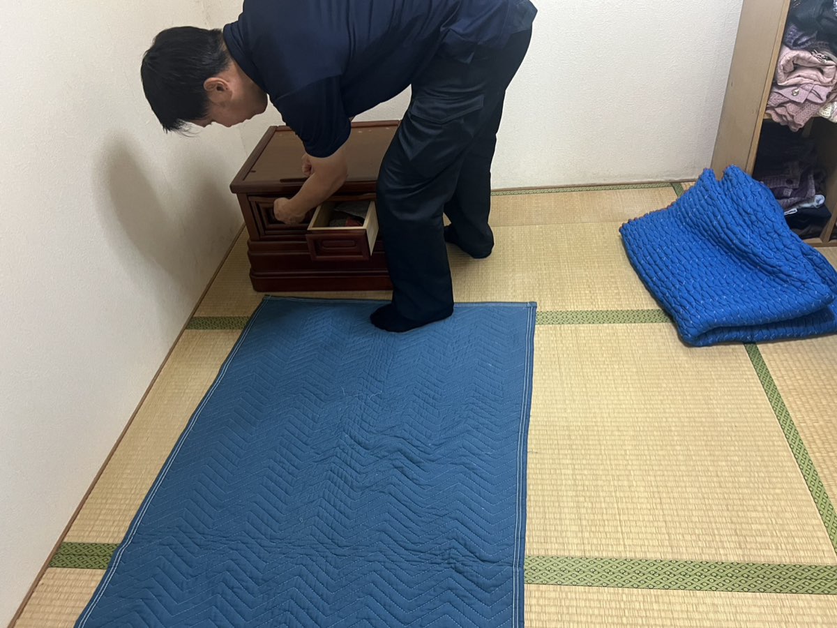 兵庫県小野市 お仏壇処分の作業風景。スタッフが床を養生し経机の中身を確認している様子